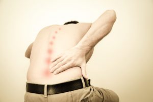 man bent over grabbing lower back in pain