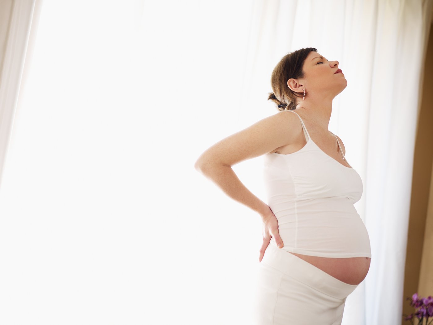 pregnant woman grabbing lower back in pain